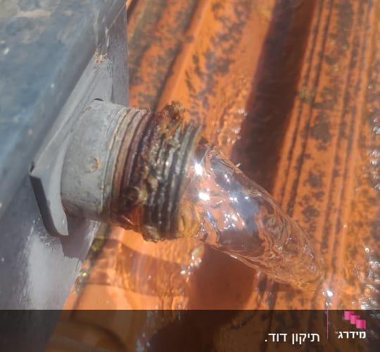 מים זורמים מצינור על גג רעפים כתום